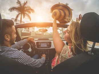 happy people having fun in convertible car in summer vacation - young friends laughing on cabrio auto outdoor - main focus on girl face - travel, youth lifestyle, holidays and friendship concept