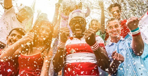multiracial football supporters celebrating begin of world competition - happy multiracial people having fun together outside of stadium - main focus on black man face - sport and bonding concept
