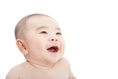happy asian baby looking something