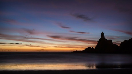 rocks silhouette at piha beach, west auckland, new zealand