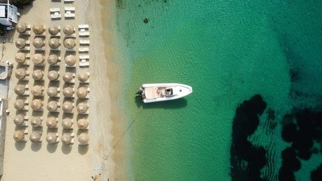 aerial drone photo of famous turquoise clear water beach of psarou in iconic island of mykonos, cyclades, greece