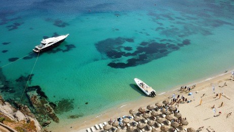 aerial drone photo of famous turquoise clear water beach of psarou in iconic island of mykonos, cyclades, greece