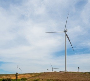 landscape wind turbines generating electricity with blue sky and mountain