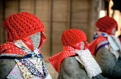 jizo bosatsu or japanese monk stone statue with red knitted hat at narita san shinsho ji temple, narita, chiba, japan
