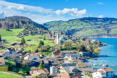 brienz town on lake brienz by interlaken, switzerland, with snow covered alps mountains in background
