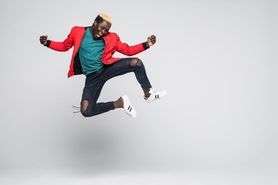 portrait of a cheerful afro american man jumping isolated on a white background