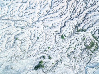 aerial view of snow mountain terrain and erosion the surface around the volcano at winter. beautiful bird eyes view of nature and landscape. top view from drone. texture of the earth.