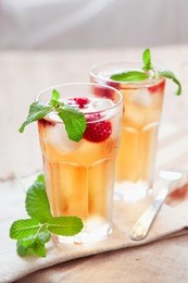 refreshing summer drink with syrup, raspberry, mint and ice. glasses with cold and healthy beverage, place for text