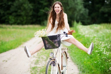 woman riding bicycle with her legs in the air