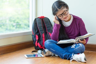 happy smiling girl reading a book for exam at classroom corner,education and school concept.