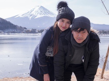 asian couple and valentines day travel concept.couple travelers man and woman travel the beautiful nature of mt. fuji in japan. travel and attractions concept.