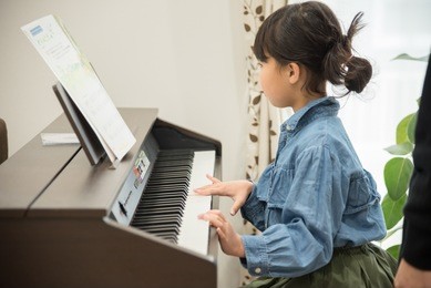 girls practicing piano in the living room