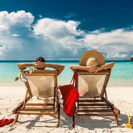 couple in loungers on a tropical beach at maldives