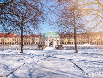 munich, germany, winter view with snow of the hofgarten round pavilion in the baroque garden.sunny day lighting flare blue sky.