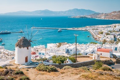 panoramic view at mikonos, view from the hill with windmill and mykonos town greece