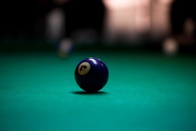 sport billiard balls on green billiard table in pub. on going billiard game. competitive players trying to find out the winner of the round.