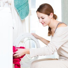 housework: young woman doing laundry (shallow dof; color toned image)