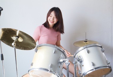teen girls are having fun playing drum sets in music class
