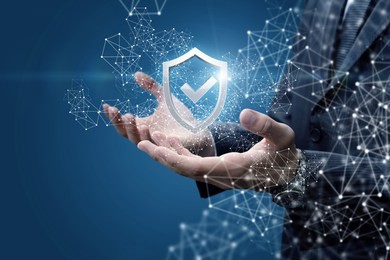 businessman showing a shield with a check mark on a blue background.