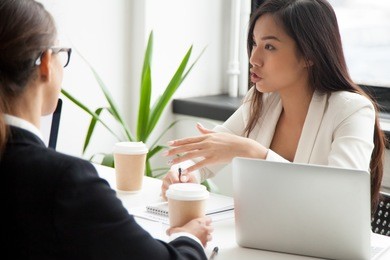serious asian businesswoman discussing project or brainstorming talking working with colleagues at meeting, millennial chinese manager making offer, explaining new idea to partners during negotiation