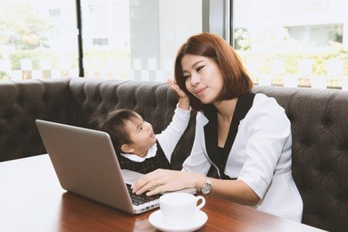 relationship of asian mother and daughter concept.  little girl play with mother while working on laptop computer weekend at home.