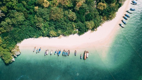 aerial shot of phra nang beach in thailand with long tail boats