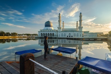 an unknown guy is enjoying the beautiful morning vibe of kota kinabalu mosque in kota kinabalu, sabah.