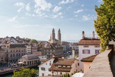 aerial view of historic zurich city center with famous grossmunster church and river limmat from lindenhof park, zurich, switzerland. summer landscape, sunshine weather, blue sky and sunny day