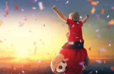 cute little child dreaming of becoming a soccer player. boy with man playing football on sunset. family sport.