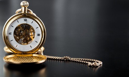 photo of opened old vintage pocket clock against the black background