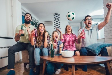 happy friends or football fans watching soccer on tv and celebrating victory at home.friendship, sports and entertainment concept.