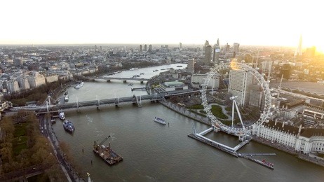 city of london skyline high angle aerial view of london eye wheel, thames river, hungerford bridge, whitehall gardens along the riverside at sunset