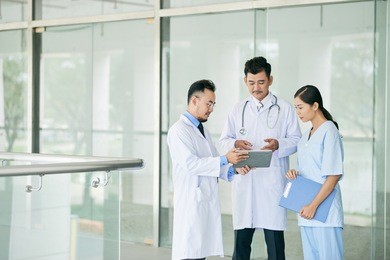 team of doctors discugging information in digital tablet