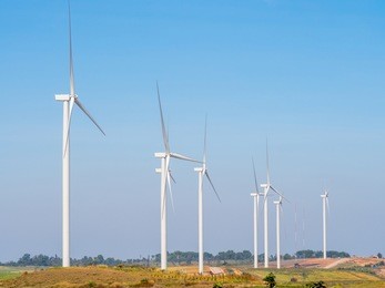 landscape wind turbines generating electricity with blue sky and mountain