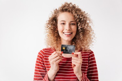 close up portrait of happy young girl with curly hair showing credit card isolated over white background