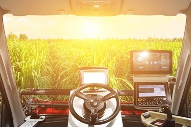 interior cabin of smart agricultural tractor a combine and harvesting in sunrise. 