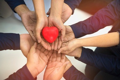 group of hands holding red heart, health care, love, organ donation, family insurance and csr concept