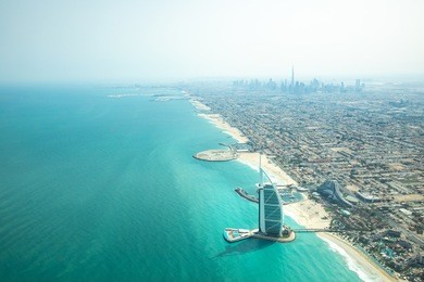 aerial view of dubai city beach, waterfront and coast line on a clear sunny day.