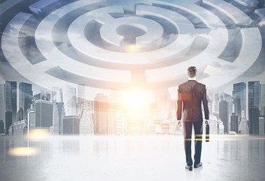rear view of a young businessman with a suitcase looking at a maze in a city sky. concept of management and challenge of business. toned image double exposure