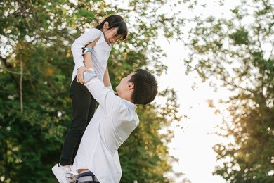 father carrying daughter on back outdoors