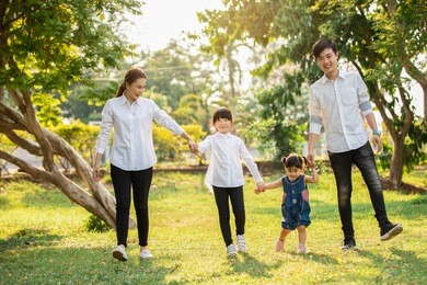 asian family are going out of the house , parents and children were walking hand in hand together a happy in garden.