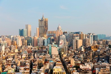 beautiful urban skyline of vibrant macao city on a sunny summer day, with the famous landmark luxury grand lisboa hotel & casino standing among modern buildings under blue clear sky, in macau, china 