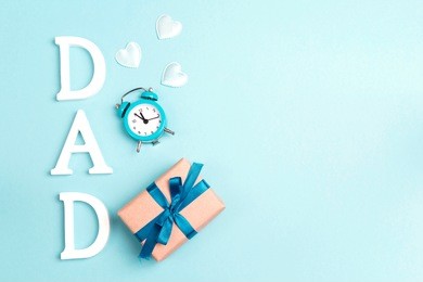 fathers day background with white letters, alarm clock and gift box. place for text. happy fathers day concept. 