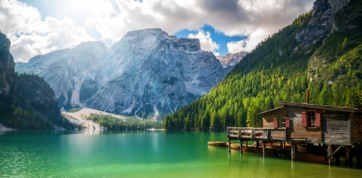 braies lake in dolomites mountains forest trail in background, sudtirol, italy. lake braies is also known as lago di braies. the lake is surrounded by forest which are famous for scenic hiking trails.