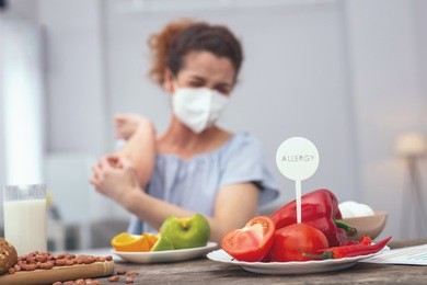 protection from allergy. young girl protecting her breathing passages with a respiratory mask so not to inhale a smell of vegetables causing her suffer from allergies
