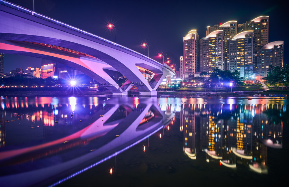 xindian night view - city skyline and water reflection at night in new taipei, taiwan.