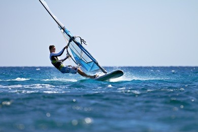 side view of young windsurfer passing by