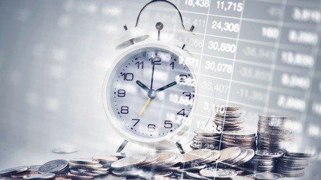 double exposure of graph with clock and rows of coins for time of finance and business concept.