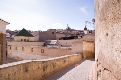 view of the sunny street and houses of the old medina in fes city