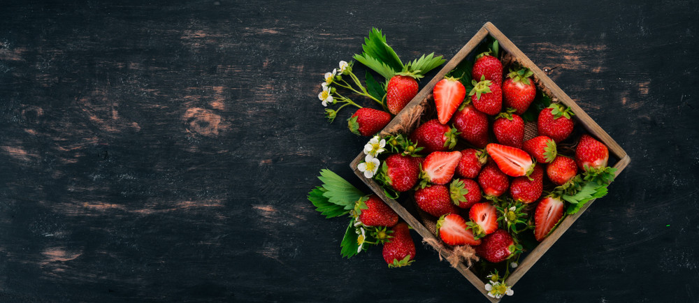 fresh strawberries in a wooden box. on a wooden background. top view. copy space.